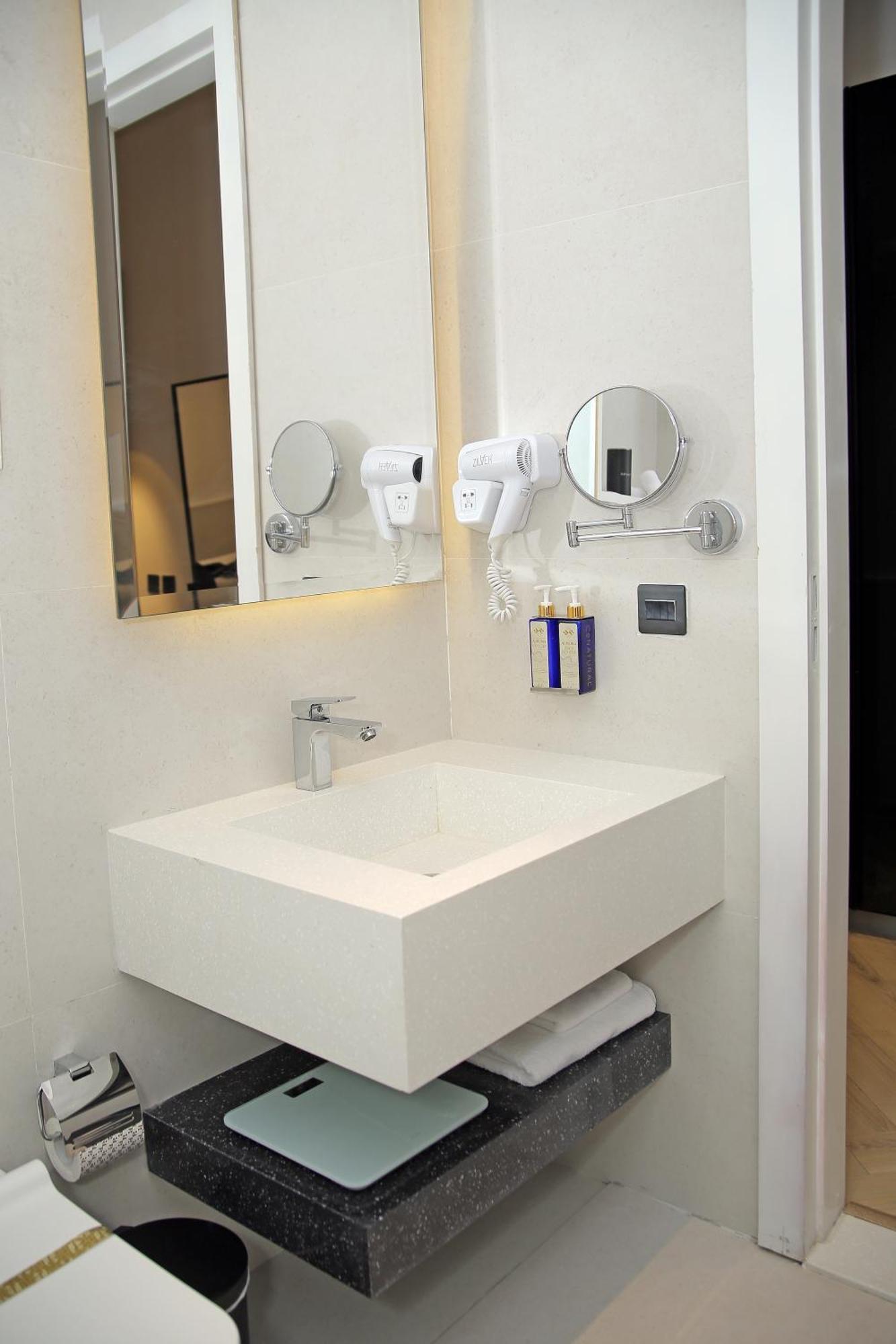 Ambiance Boutique Art Hotel Lahore Pokoj fotografie A wall mounted hair dryer in a hotel bathroom